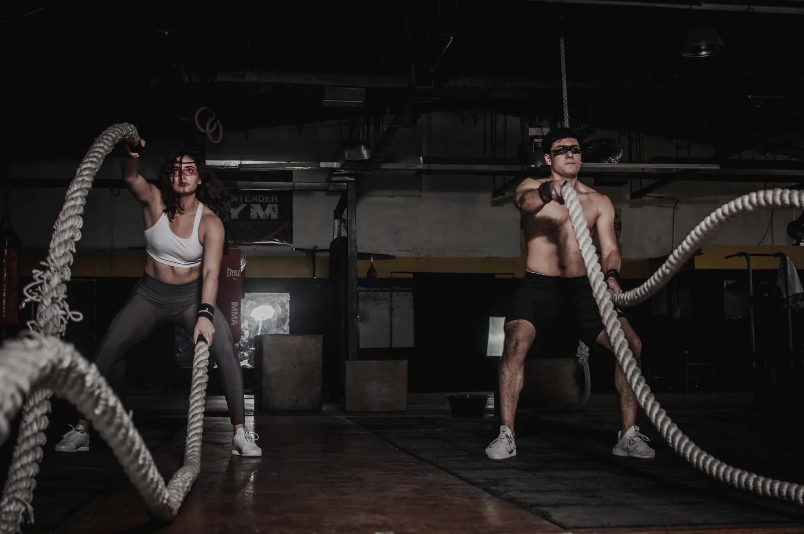 Two athletes training with battle ropes