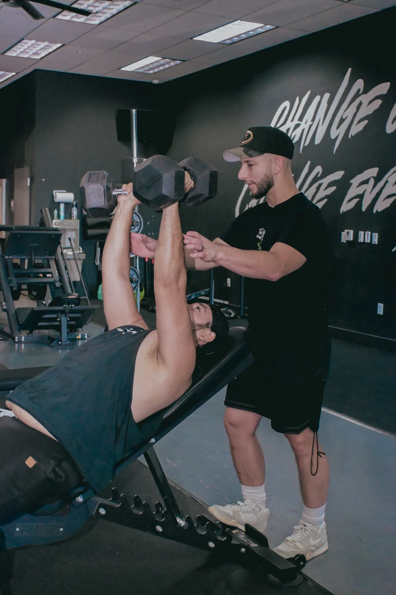 Coach spotting a dumbbell press